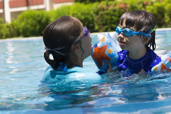 Chica feliz y niño disfrutando en la piscina —  Fotos de Stock