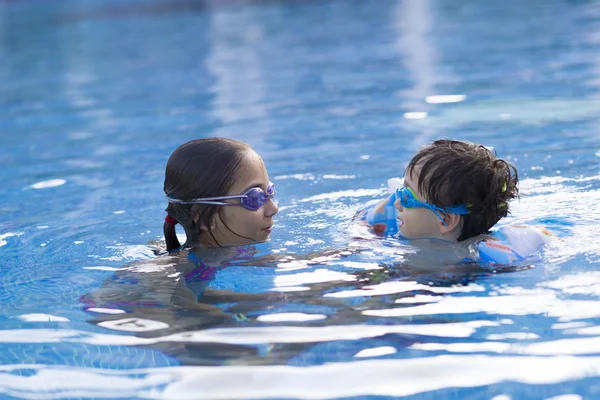 Chica feliz y niño disfrutando en la piscina —  Fotos de Stock