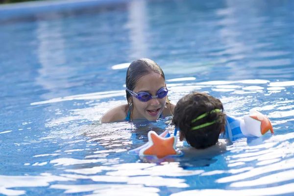 Chica feliz y niño disfrutando en la piscina —  Fotos de Stock