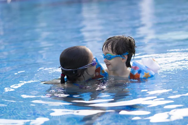 Chica feliz y niño disfrutando en la piscina —  Fotos de Stock