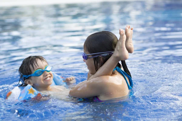 Chica feliz y niño disfrutando en la piscina —  Fotos de Stock