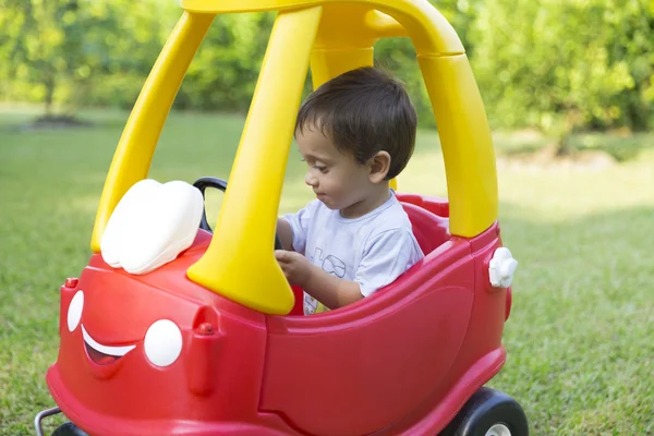 Glücklicher kleiner Junge am Steuer seines Spielzeugs — Stockfoto