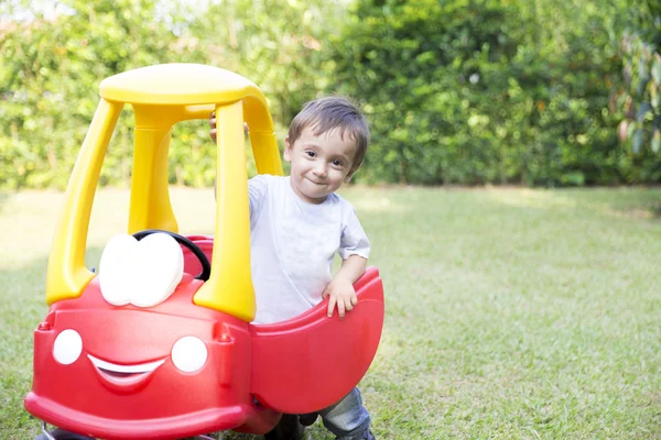 Joyeux petit garçon conduisant son jouet — Photo