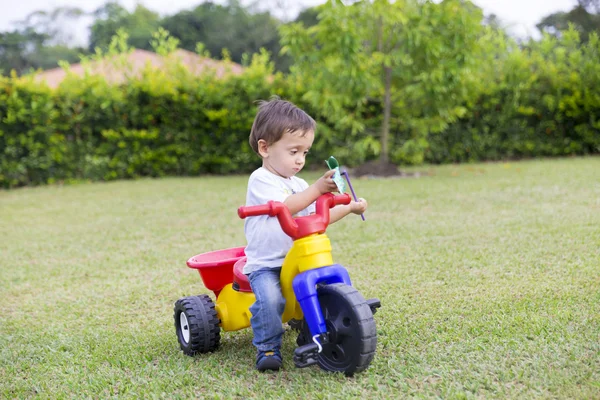 Feliz niño conduciendo su juguete — Foto de Stock