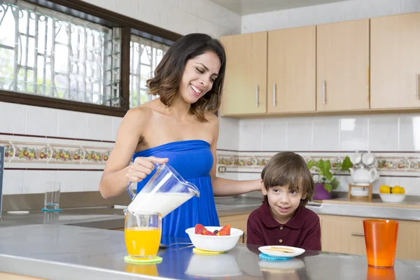 Mãe feliz e seu menino tomando café da manhã — Fotografia de Stock