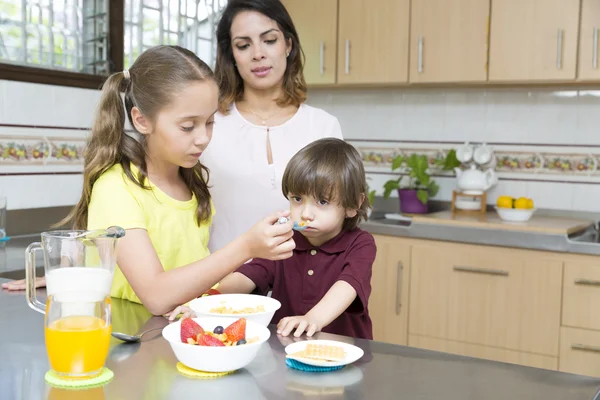 Mooie moeder en haar kinderen ontbijten — Stockfoto