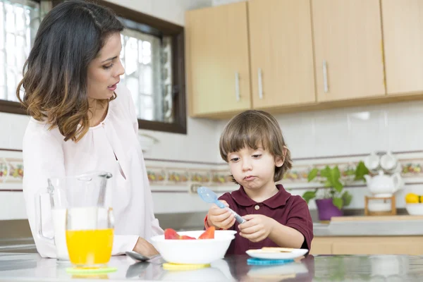 Feliz madre y su hijo desayunando — Foto de Stock