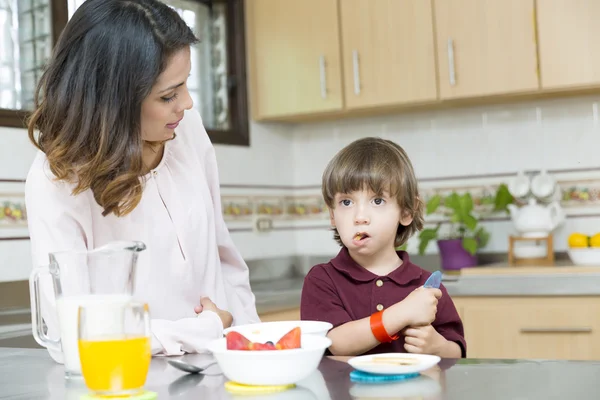 Mãe feliz e seu menino tomando café da manhã — Fotografia de Stock