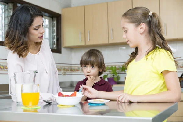 Mooie moeder en haar kinderen ontbijten — Stockfoto