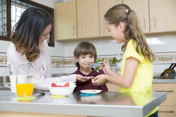 Madre encantadora y sus hijos desayunando — Foto de Stock