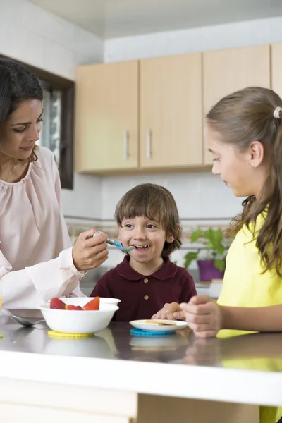 Mooie moeder en haar kinderen ontbijten — Stockfoto