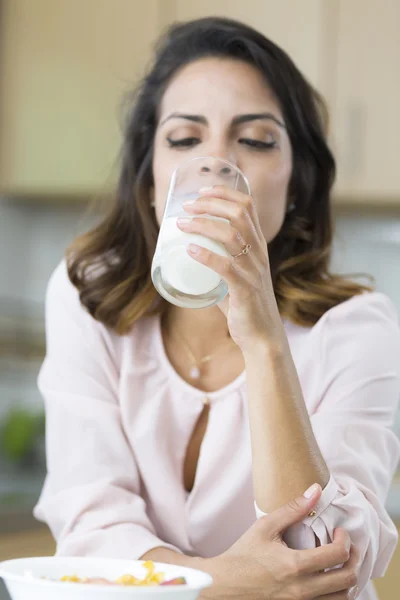 Attractive young woman drinking milk