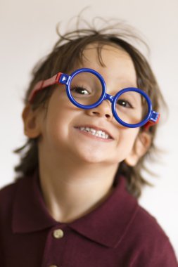 Mutlu küçük çocuk gözlük takıyor