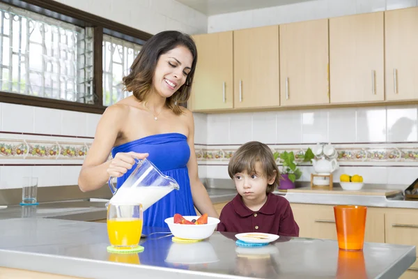 Mãe feliz e seu menino tomando café da manhã — Fotografia de Stock