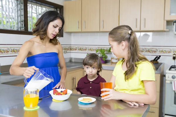 Mooie moeder en haar kinderen ontbijten — Stockfoto