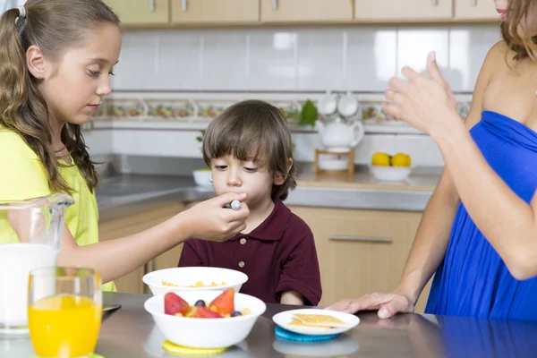 Mooie moeder en haar kinderen ontbijten — Stockfoto