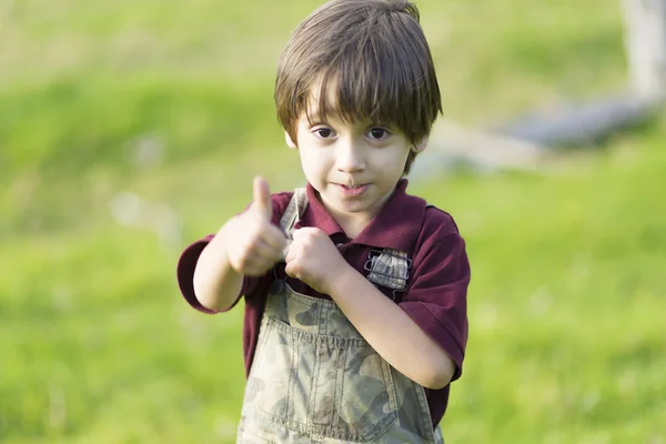 Щасливий милий хлопчик показує великі пальці вгору — стокове фото