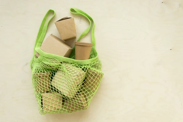 Bolsa de malha verde com caixas de embalagem. — Fotografia de Stock