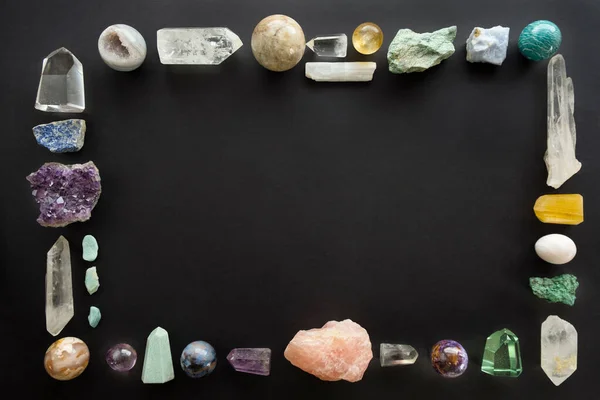 Frame gemaakt van kristallen stenen op zwarte achtergrond. Kleurrijke edelstenen en kristallen op donkere achtergrond met kopieerruimte. — Stockfoto