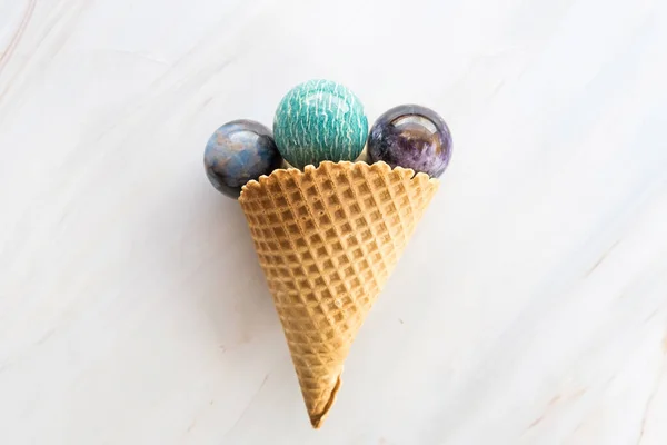 Cone de sorvete com pedras de cristal redondas no fundo de mármore como um conceito espiritual ou de cura — Fotografia de Stock
