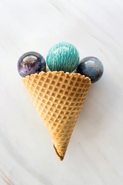 Cone de sorvete com pedras de cristal redondas no fundo de mármore como um conceito de refresco ou cura de medicina alternativa — Fotografia de Stock