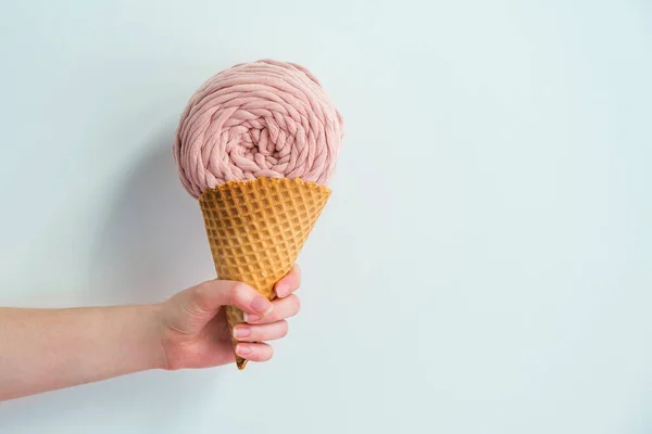 Espinha de fio macrame redondo rosa em cone de sorvete na mão da mulher. Idéia criativa de tricô macrame — Fotografia de Stock