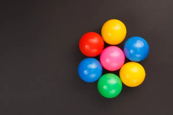 Färgglada bollar på svart — Stockfoto
