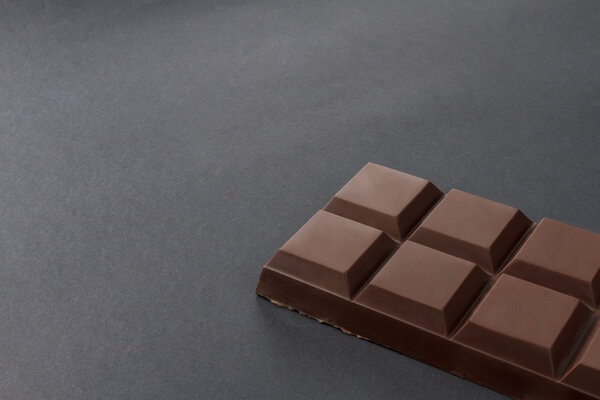 Bar of chocolate on a black