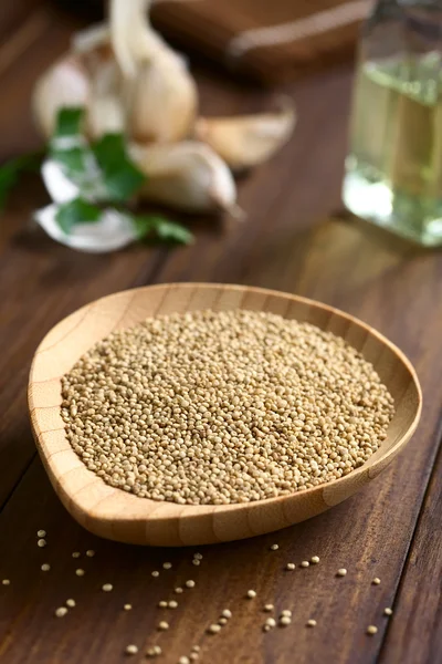 Quinoa crua em placa de madeira — Fotografia de Stock