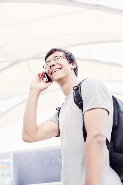 Student talking on phone in airport — Stock Photo, Image