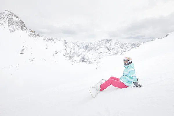 Jovem mulher sentada com snowboard — Fotografia de Stock