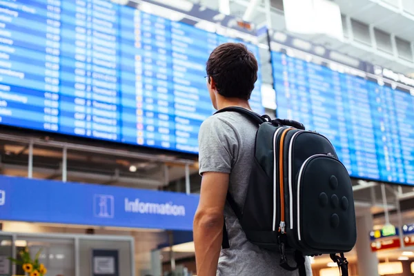 Kerel in de buurt van luchtvaartmaatschappij schema — Stockfoto