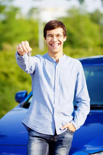 Jovem segurando a chave de seu carro novo — Fotografia de Stock