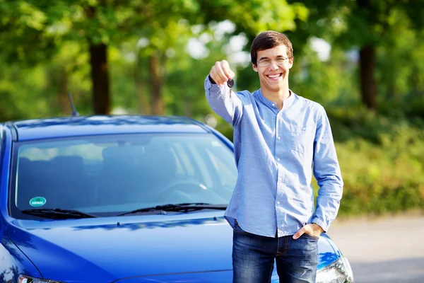 Junger Mann hält Schlüssel seines neuen Autos — Stockfoto