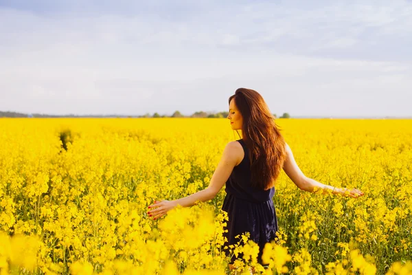 Chica disfrutando de colza floreciendo en el prado amarillo — Foto de Stock