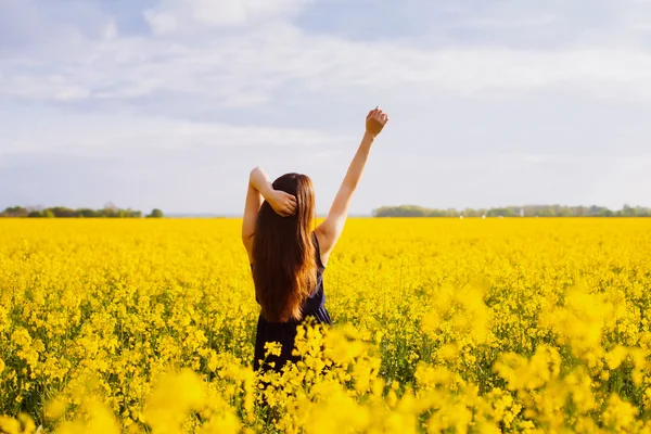 Ragazza che si gode il sole sul prato di colza — Foto Stock