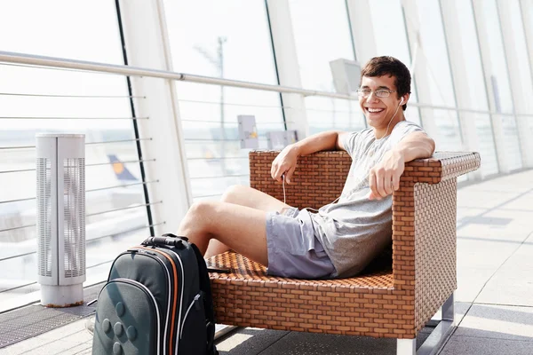 Mosolygó ember várakozás repülőtéren a járat — Stock Fotó