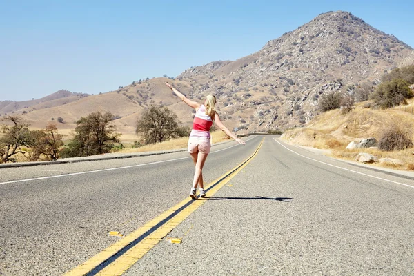 Menina andando ao longo da estrada — Fotografia de Stock