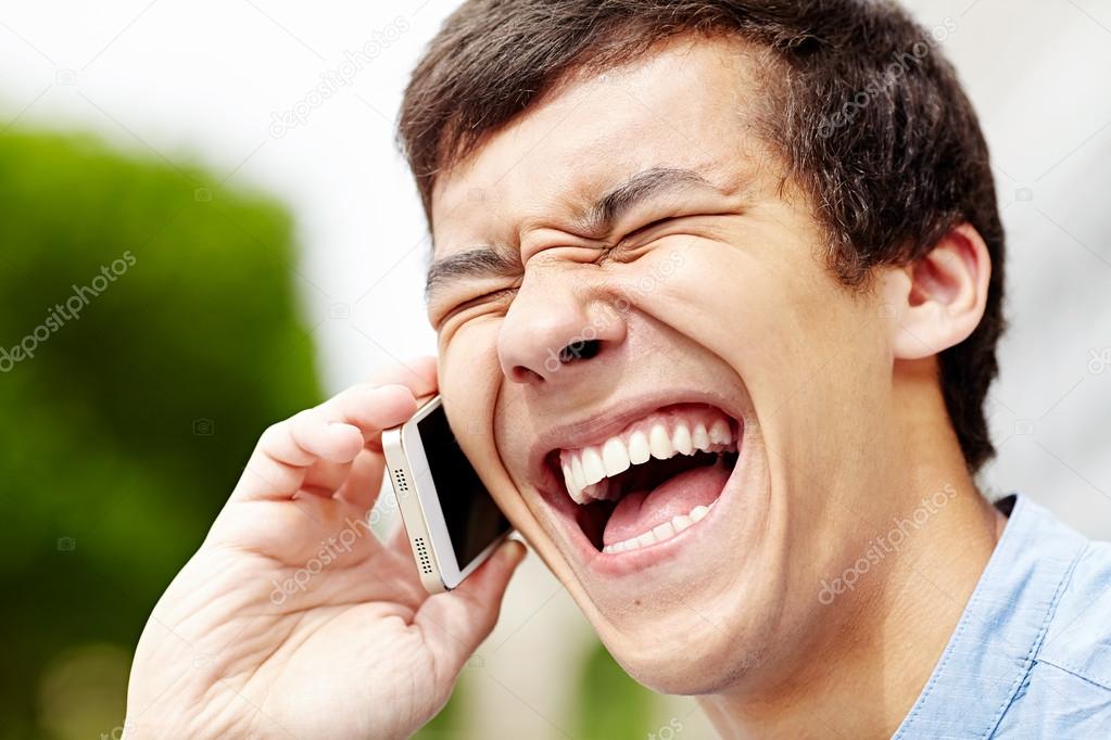 Laughing guy with smartphone closeup