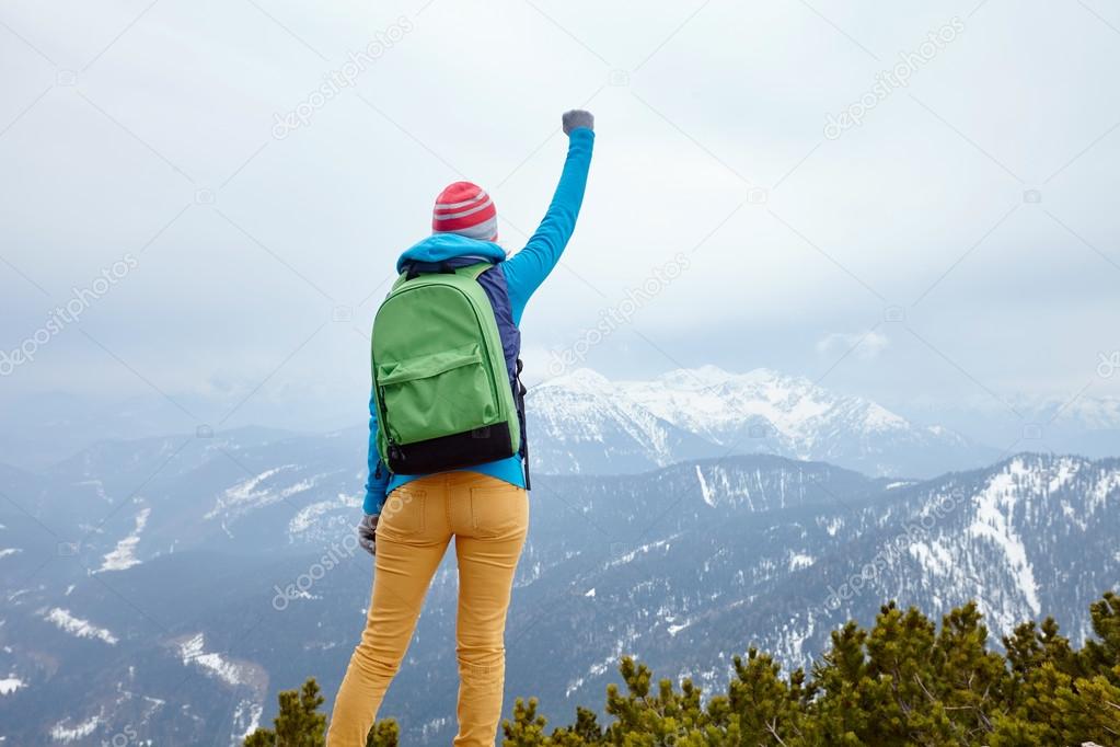 Girl with raised hand in mountains