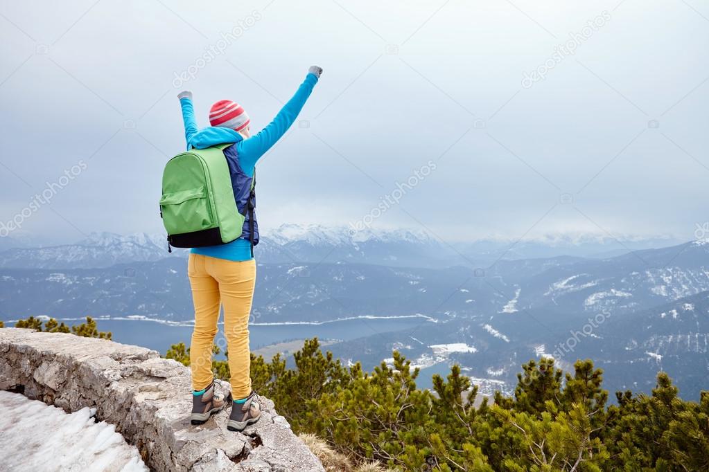 Girl with raised hands in mountains