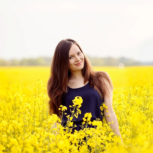 Menina sorridente no campo amarelo — Fotografia de Stock