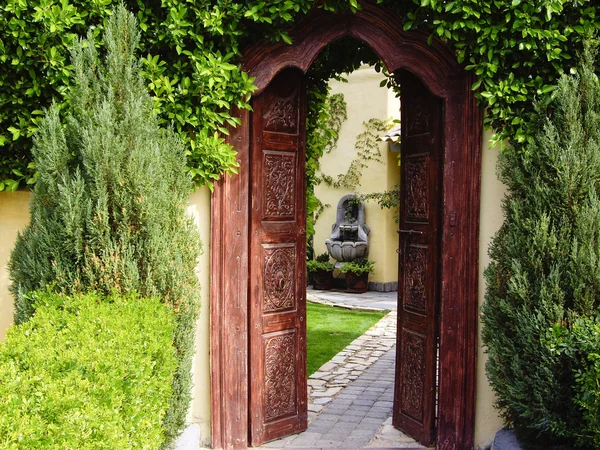 Arch door to secluded garden — стоковое фото