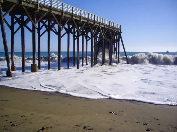 Волны бьют по деревянному пирсу в Калифорнии — стоковое фото