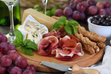 Antipasto. Kurutulmuş jambon, küflü camembert peyniri, Grissini, zeytin ve pembe üzümlü parmesan..