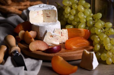 Beyaz üzümlü peynirli camembert, dilimlenmiş hurma ve erik, şarap için harika bir aperatif. 