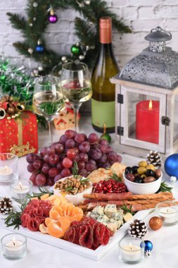 Lezzetli aperatif tabakta salam ve peynir, Parma jambonu, zeytin ve narenciye ile sarılmış Grissini. Bir Noel partisi için orijinal bir antipasto.