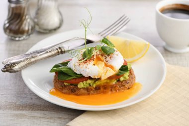  Kahvaltıda. En iyi yumurtalı Benedict tost ekmeği, yanında guacamole ve ıspanak.