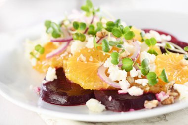 Orange salad with baked beetroot, goat cheese, microgreens and nuts. Perfect as a side dish or as a light lunch for a brunch or dinner. clipart