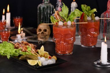 Ürkütücü Cadılar Bayramı partisi. Meksika Bloody Mary 'si Michelada. Domates suyu, tekila, acı sos, bira bardağında buzla servis edilmiş domuz pastırması, kereviz, zeytin ve soğan turşusuyla süslenmiş.
